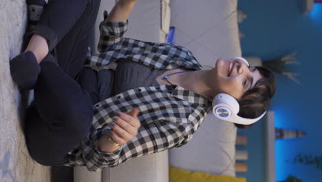 Vertical-video-of-Happy-woman-listening-to-music-with-headphones.